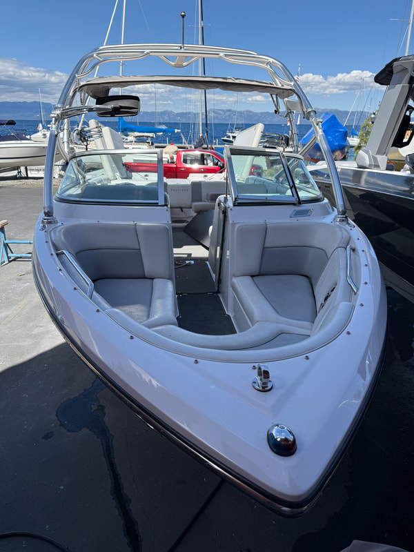Bow seating and walkthrough of Air Nautique 236 TE with lake in background