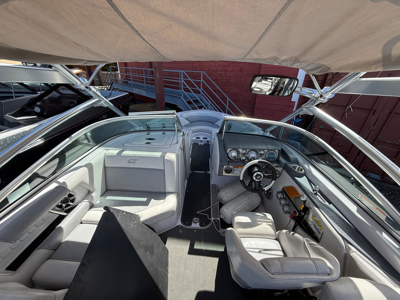 Cockpit view of helm and lounge seating under tower bimini